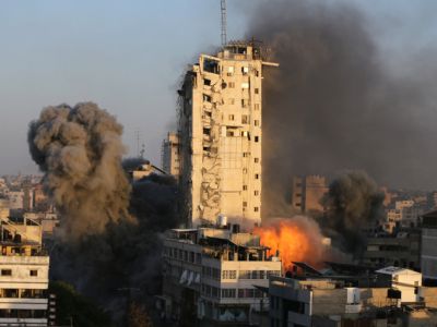 Дым и пламя поднимаются над зданием, разрушенным израильскими воздушными ударами во время вспышки израильско-палестинского конфликта в городе Газа 12 мая 2021 г. Фото: Reuters / Ibraheem Abu Mustafa